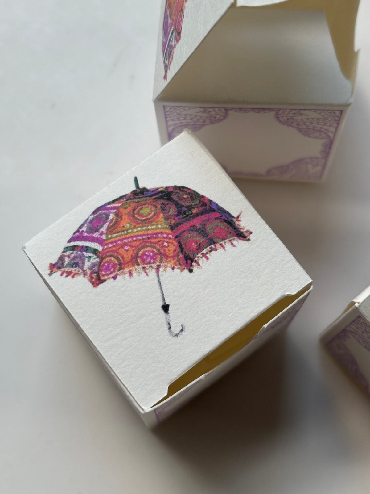Colourful umbrella design Mehndi favour boxes by The Light Candle Co, ideal for Indian and Pakistani weddings, henna parties and pre-wedding celebrations.